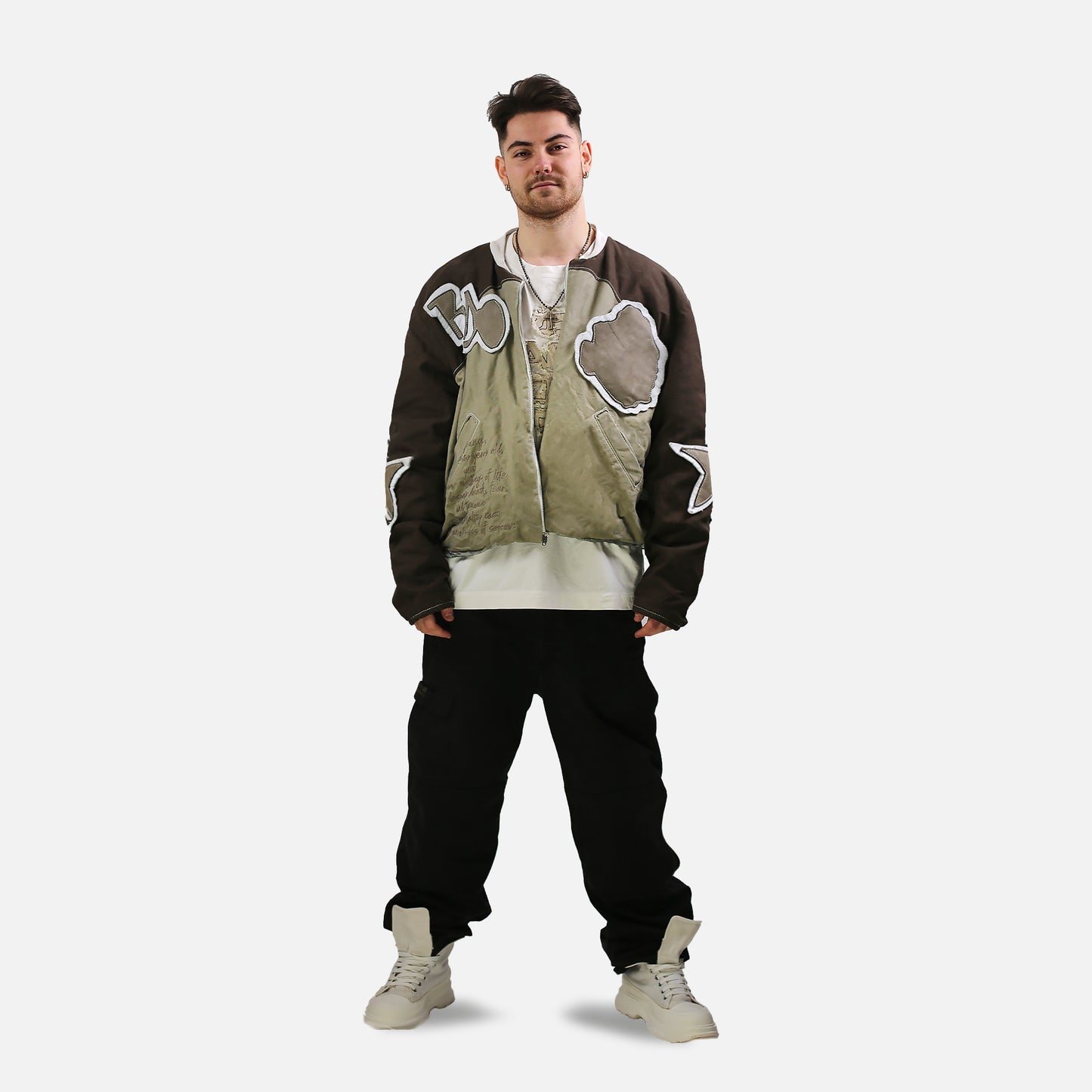 Man wearing a unique jacket with abstract designs on a white background
